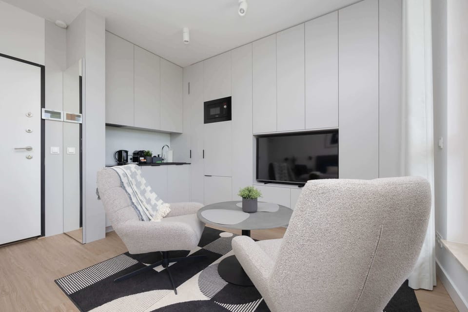A modern living and dining area with integrated kitchen, neutral tones, and a relaxing layout.