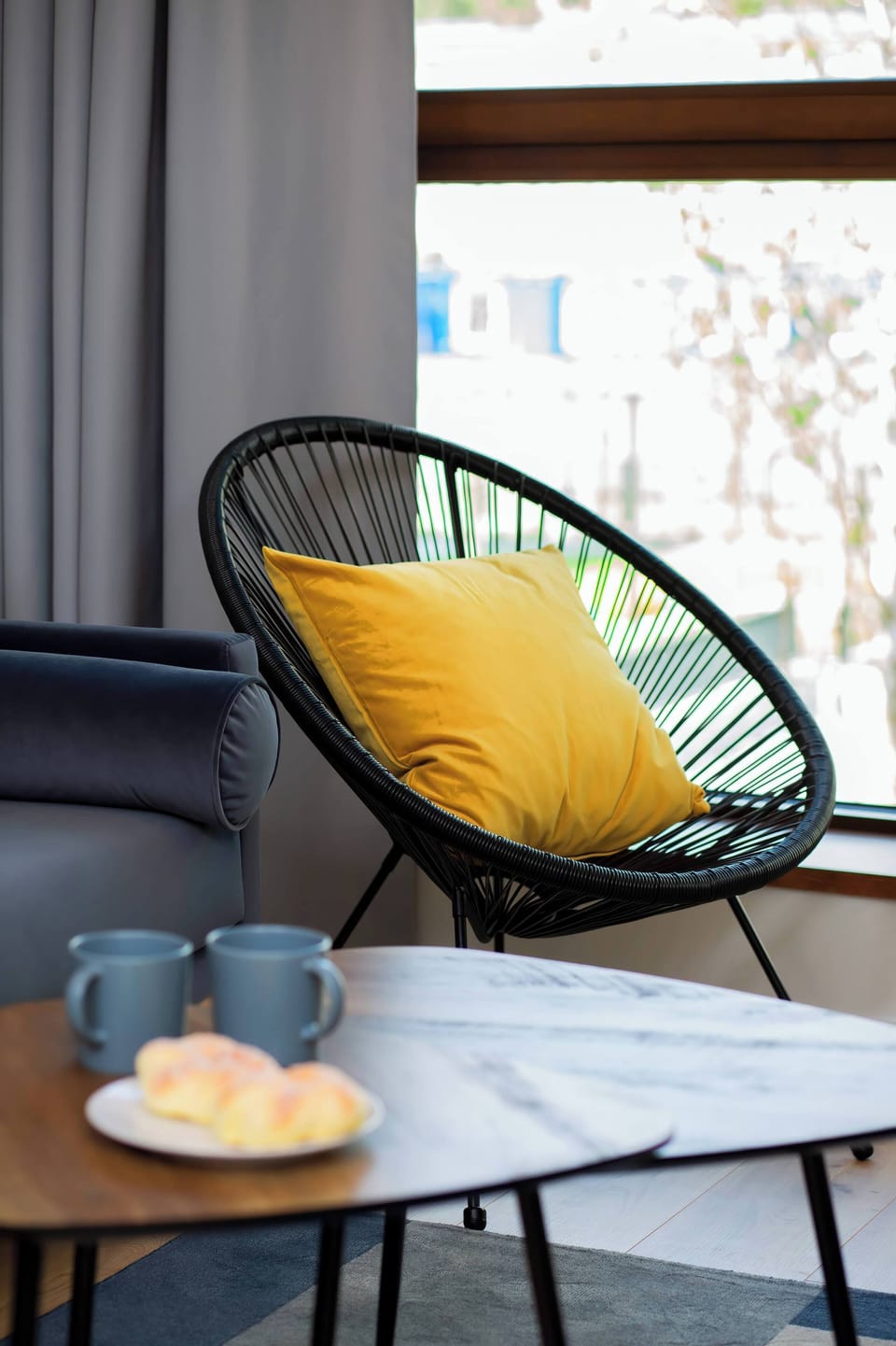 A snug corner featuring a modern armchair, a small table, and decorative elements.