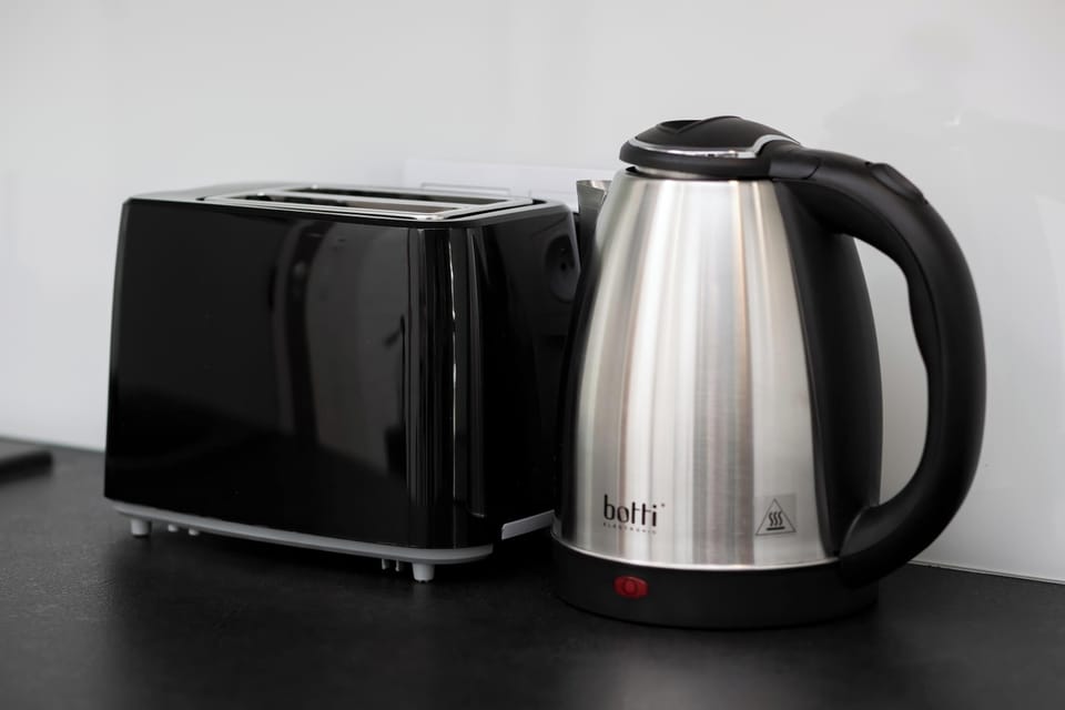 A close-up of a kettle and toaster on the kitchen countertop.