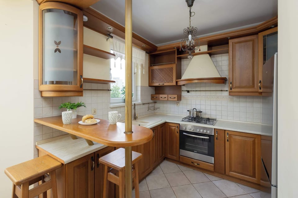 A functional kitchen with upper and lower wooden cabinets and built-in appliances. Ideal for preparing home-cooked meals.