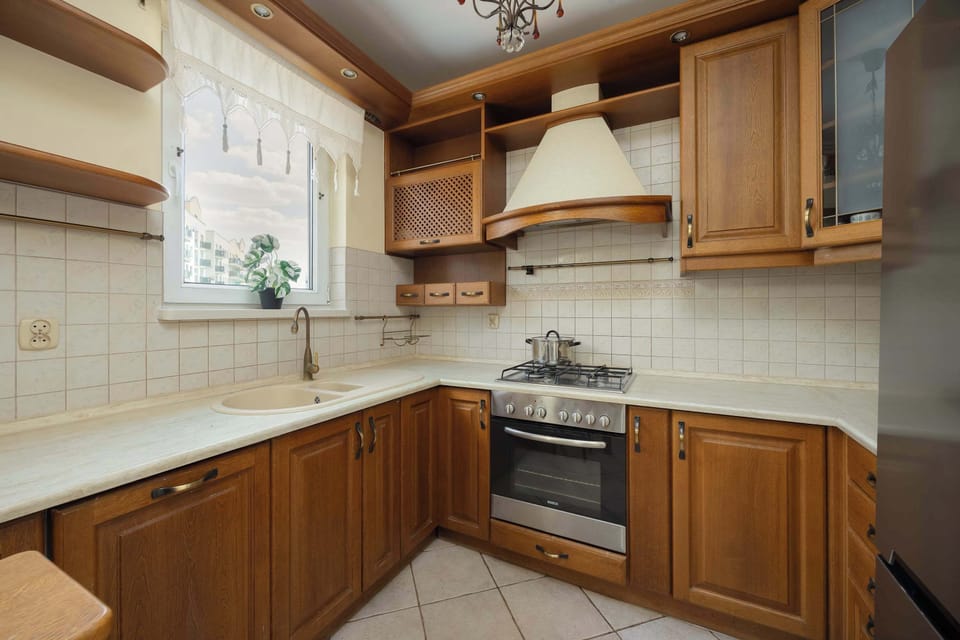 A charming, well-lit kitchen with tiled walls and countertops. Complete with an oven, stove, and sink for everyday convenience.