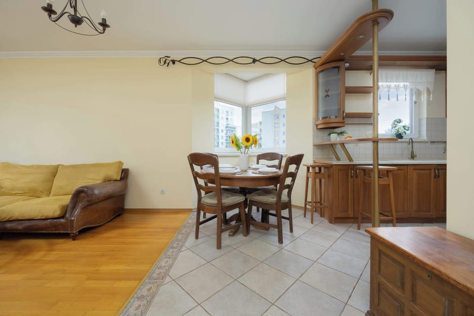 An inviting living area featuring a sofa, armchair, and dining table. The open layout creates a spacious and comfortable atmosphere.