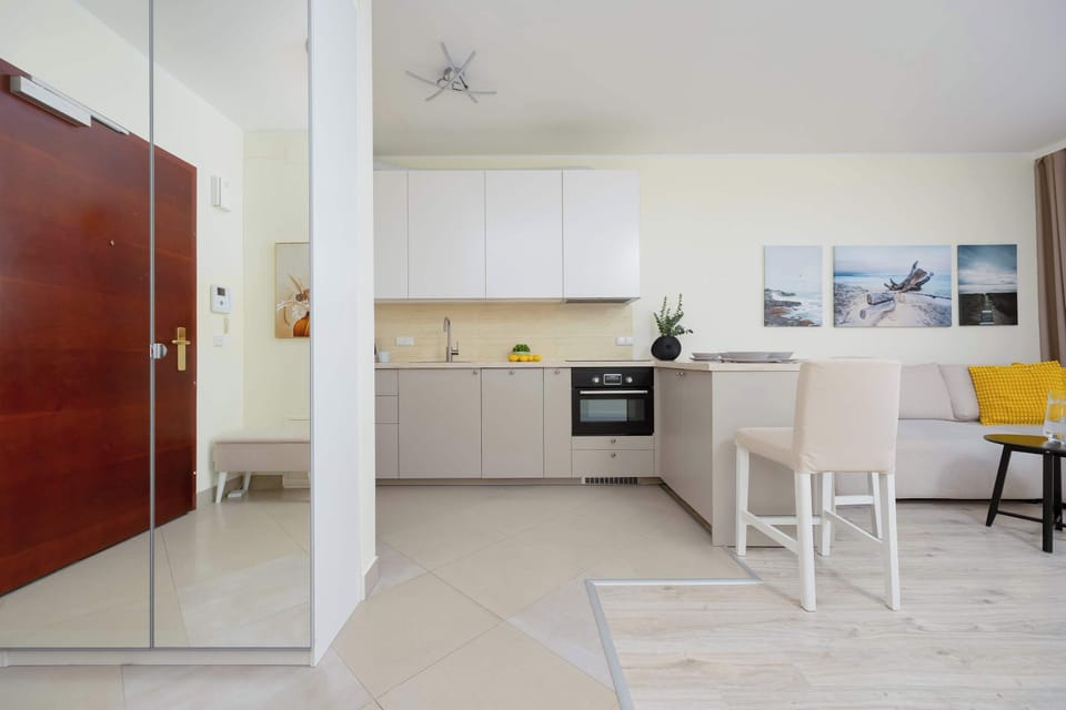 Modern kitchenette with dining area and living room.