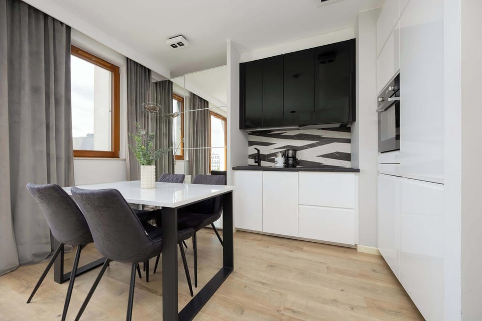 A compact, fully equipped kitchen with a black-and-white backsplash.