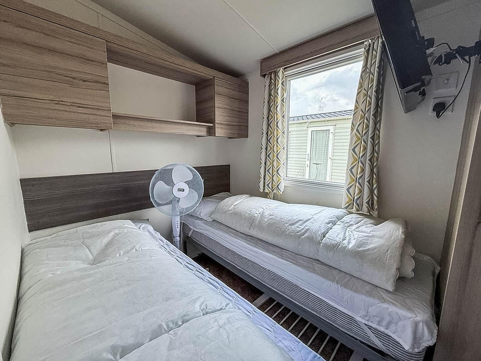 Cozy twin bedroom with natural light and modern storage