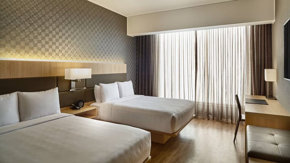 Recharge in sunlit comfort with workspace and blackout drapes.