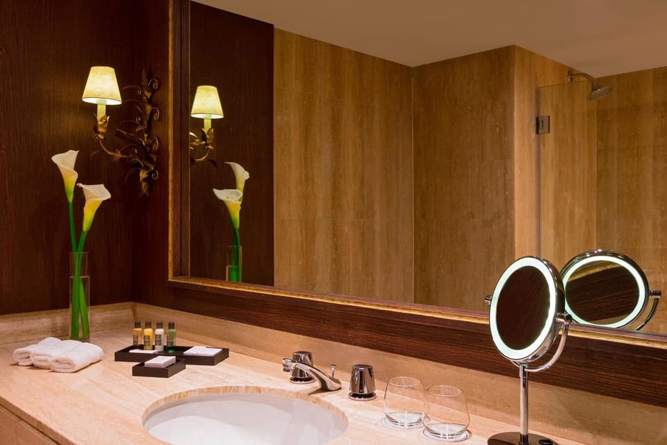 Refresh at the spacious vanity with plush towels and warm lighting.