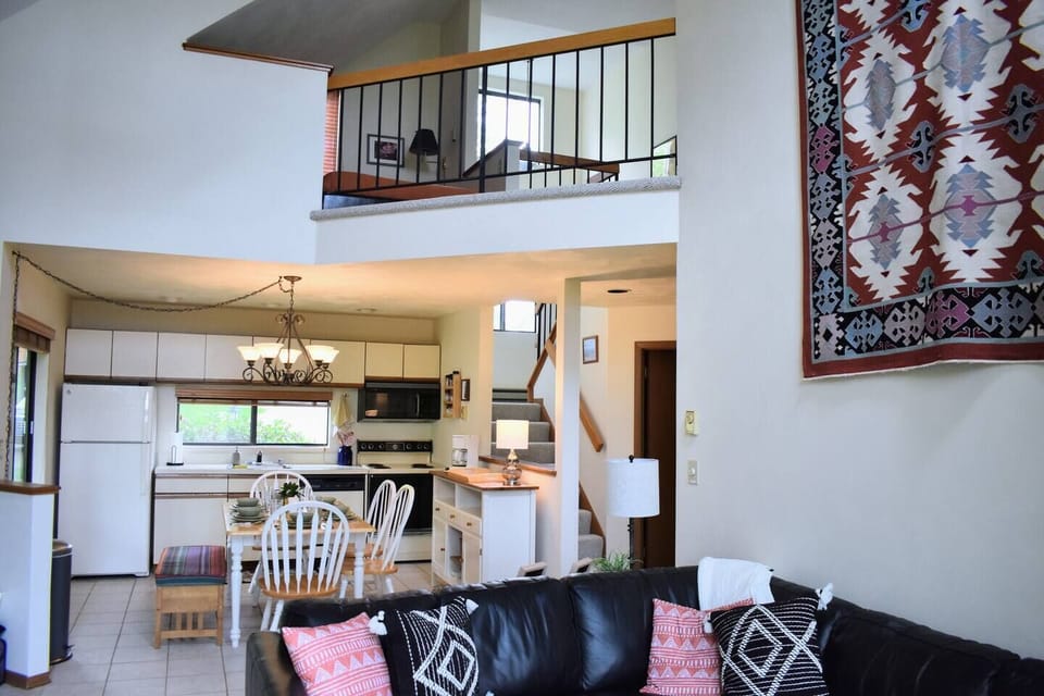 View from the living room to the kitchen and open loft above.