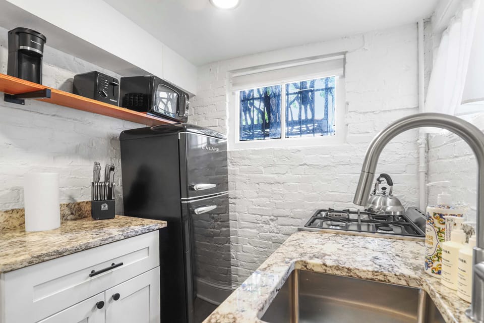 Kitchen with full sized refrigerator, microwave, toaster, coffee maker, knives, oven, stove, kettle, and provided soap. 