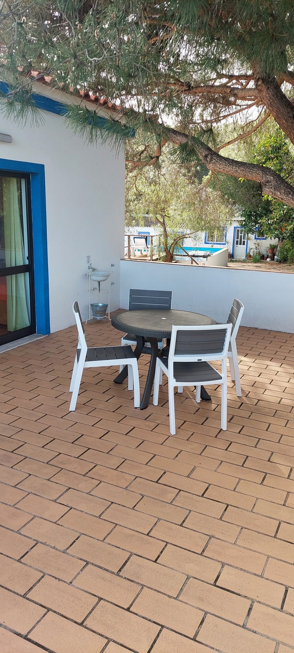 terraço com mesa e cadeiras e vista para piscina