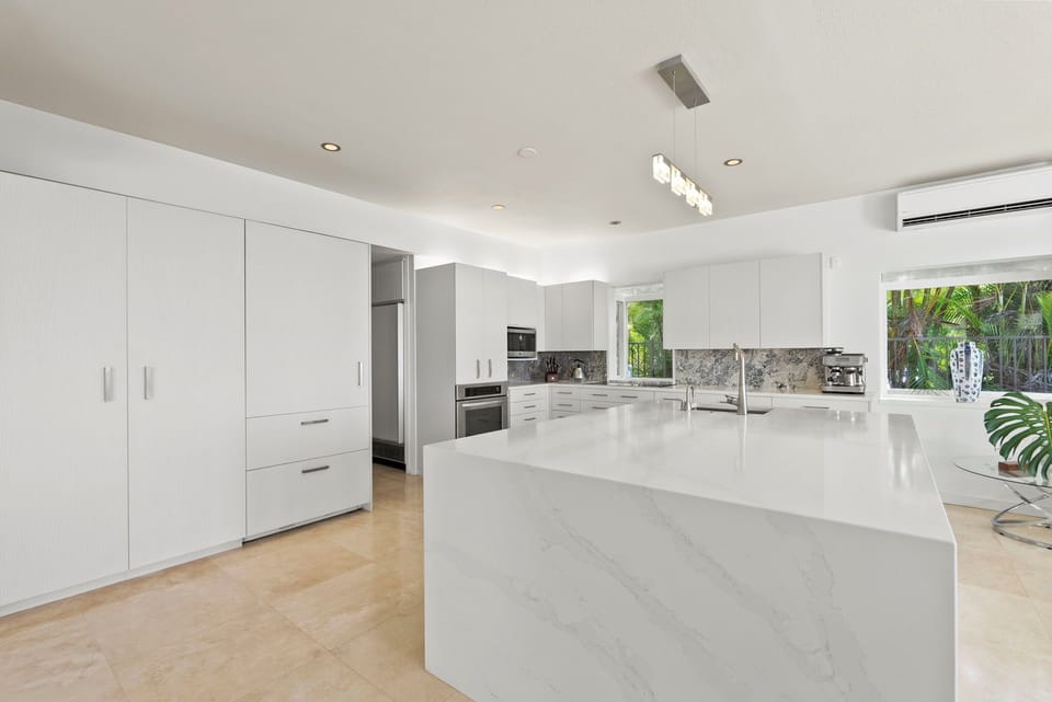 Entertain with ease in the gourmet kitchen—featuring premium appliances, marble counters, and an expansive island ideal for prepping or gathering.