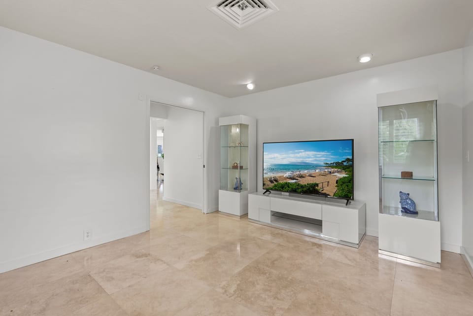 Kick back in the media lounge, where a wall-mounted TV and soft lighting create the perfect hub for movie nights or downtime.