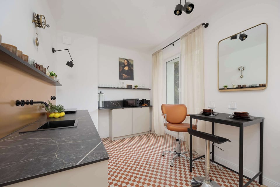 A clean and contemporary kitchen layout with a checkered floor, matte cabinets, and open wall shelves for storage.