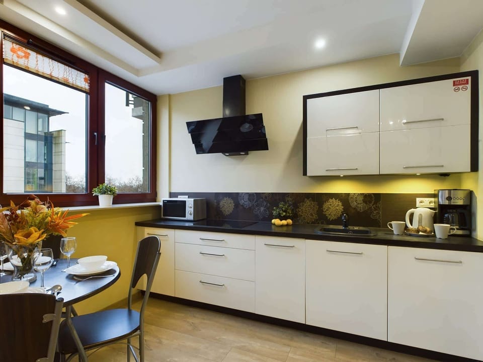 The practical kitchen space with a coffee machine, microwave, fridge and dishwasher provides space for cooking meals.