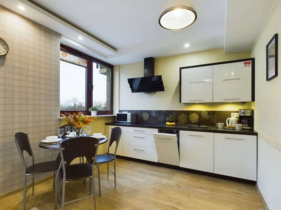 A small kitchen area with vibrant backsplash lighting, white cabinets, and efficient use of space.