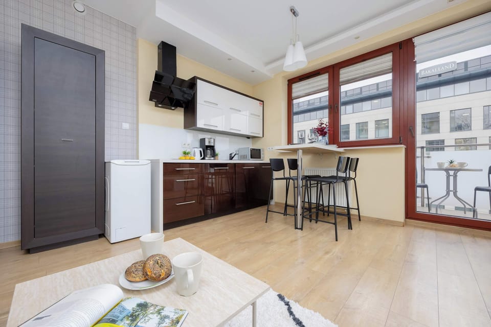 A sleek kitchen featuring dark brown cabinets, a bar-style dining table with black stools, and modern appliances.