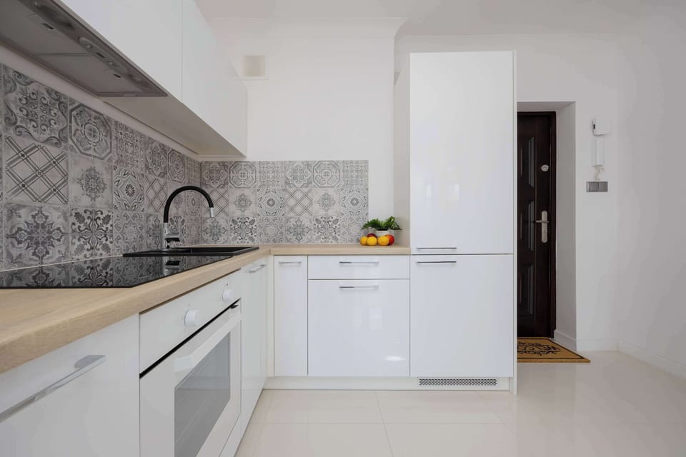 The stylish kitchen with black-and-white tiles offers full equipment for easy cooking.