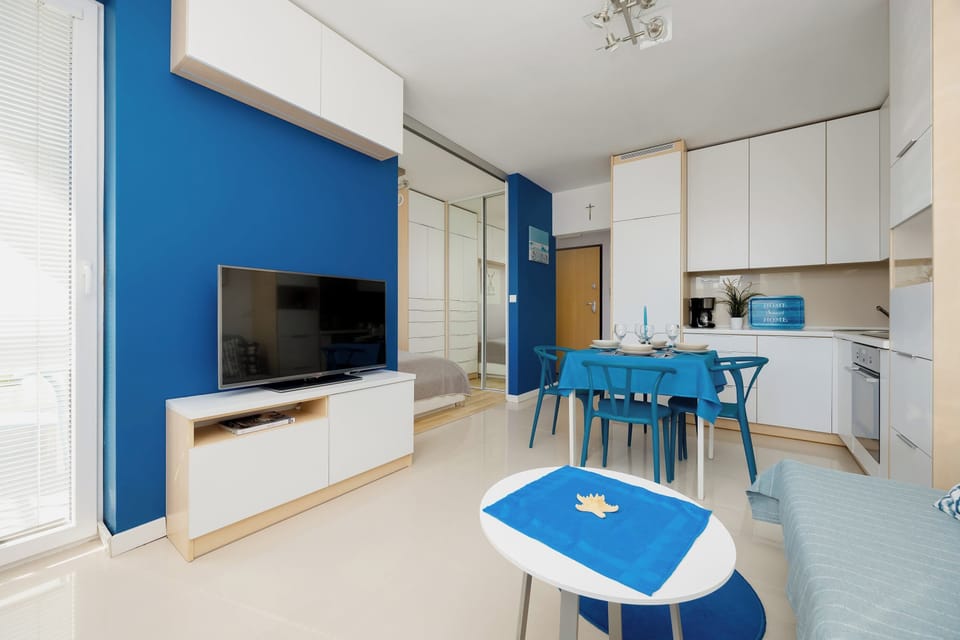 A bright living room with decorations in shades of blue. A flat-screen Smart TV provides evening entertainment. 