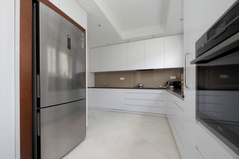 Built-in modern appliances and minimalist cabinets ensure the kitchen's functionality.