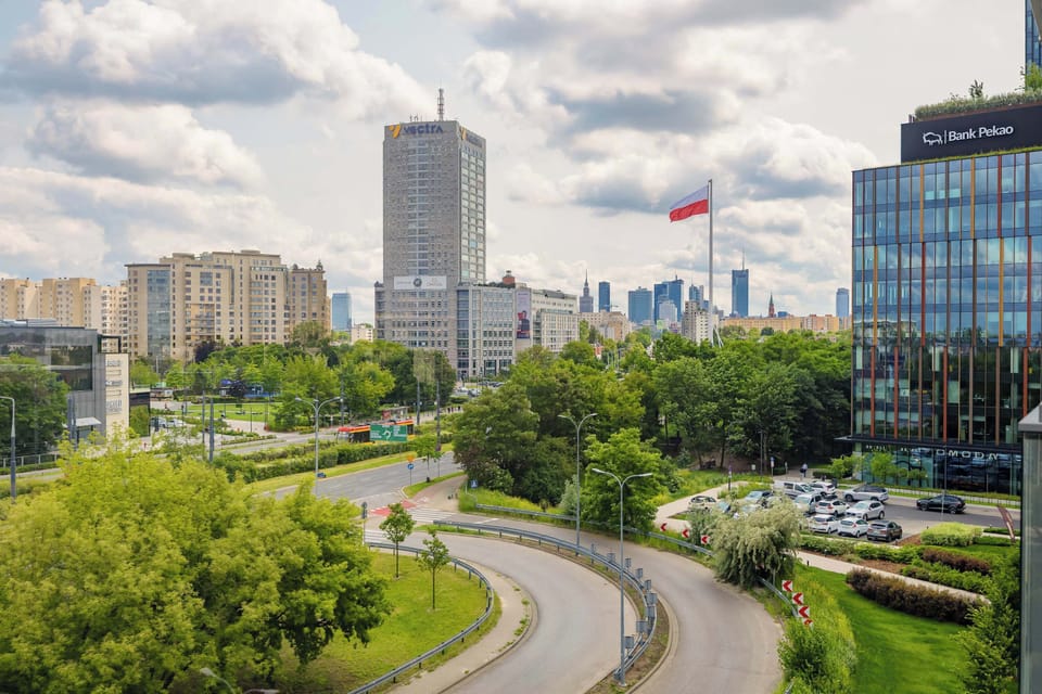 The balcony offers an impressive view of modern skyscrapers in the center of Warsaw, creating a unique backdrop for morning coffee or evening relaxation with a panorama of the bustling city.