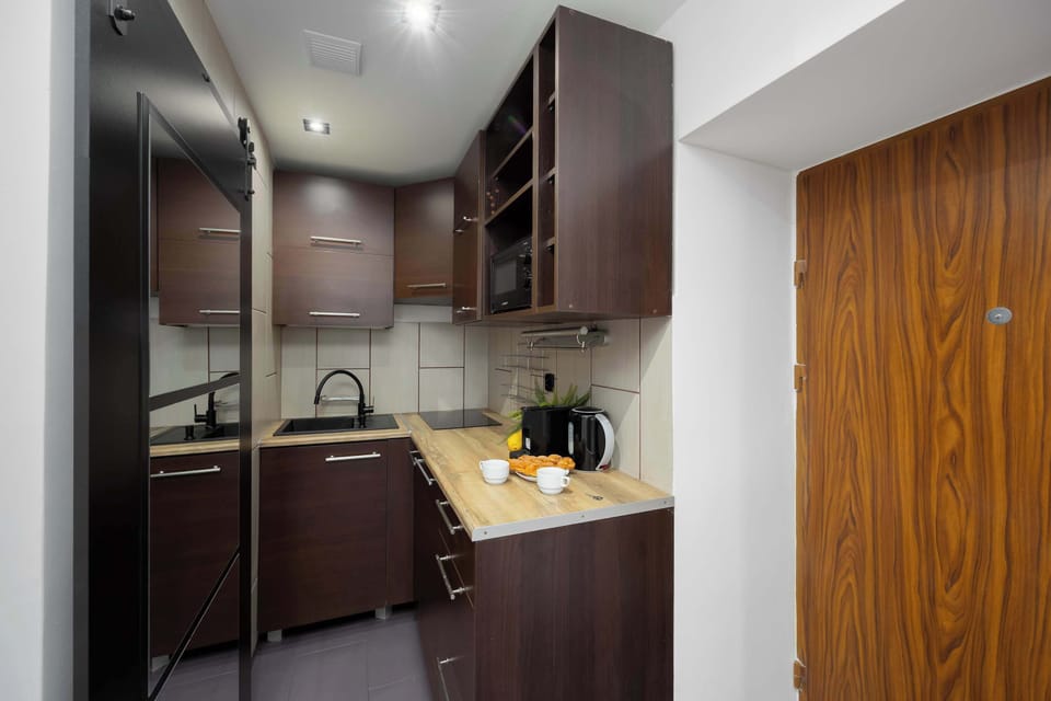A compact kitchen with wooden cabinets, modern appliances, and a cozy atmosphere.