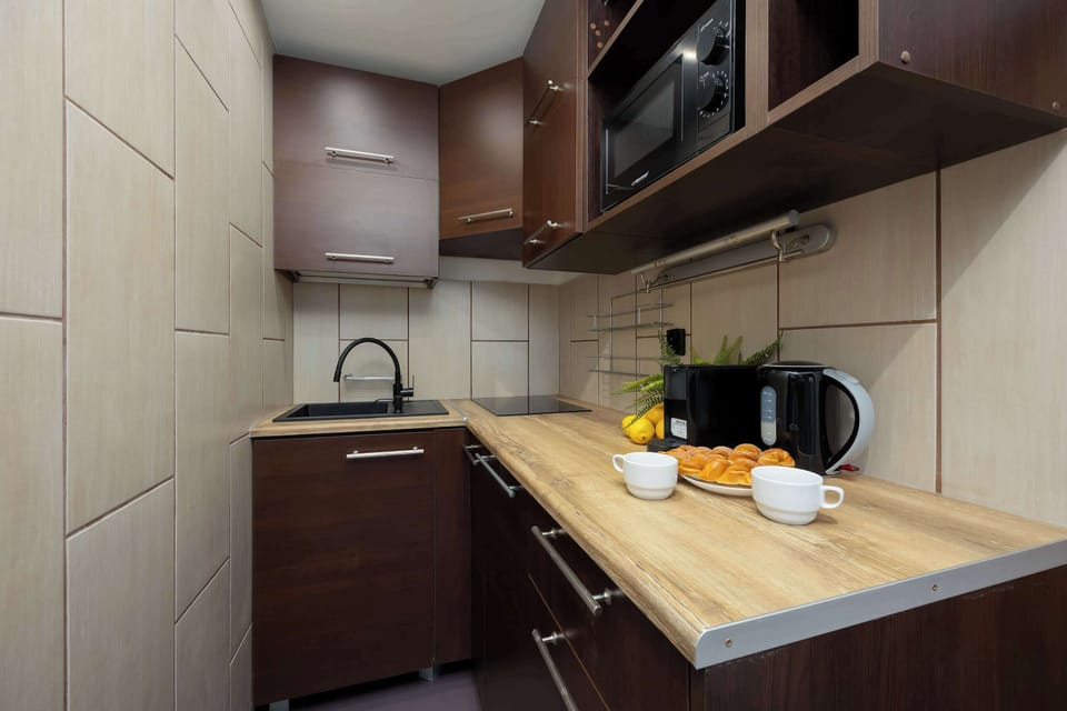 A compact kitchen with wooden cabinets, modern appliances, and a cozy atmosphere.