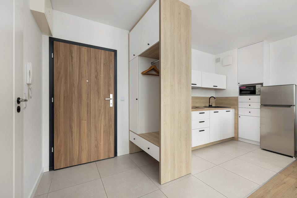 The view of the kitchen from the bright spacious hallway, with a large closet, shows the full equipment, which combines functionality with aesthetics.