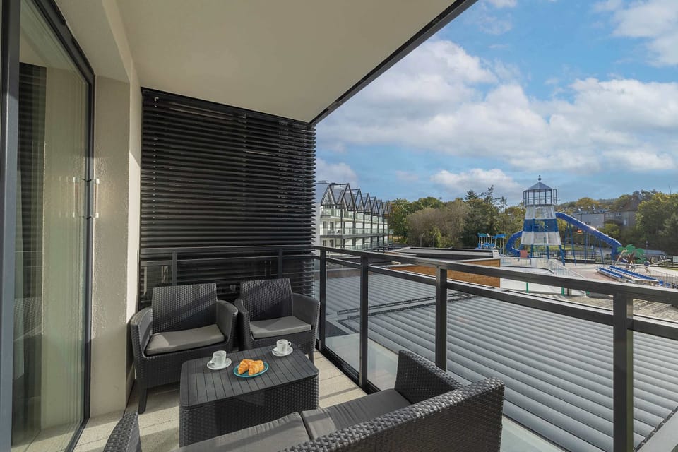 This outdoor shot focuses on the apartment balcony, offering a view of nearby buildings and a serene atmosphere for relaxation.