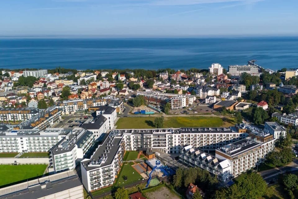 A panoramic view of the residential area, featuring modern buildings and the coastline in the background.
