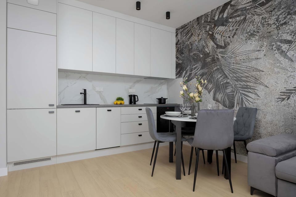 A dining nook next to the kitchen with elegant place settings and patterned wall art.