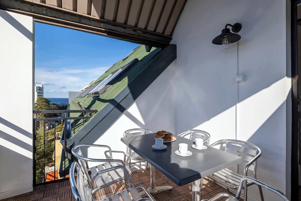 A beautiful balcony with a table and chairs, perfect for enjoying fresh air and scenic views.