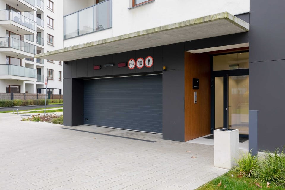 The apartment building with a well-maintained entrance surrounded by landscaped greenery.