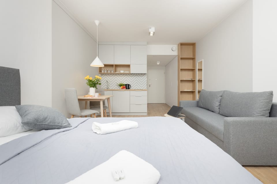 Another angle of the living room, emphasizing the bright and airy feel due to the large windows and minimalist décor.
