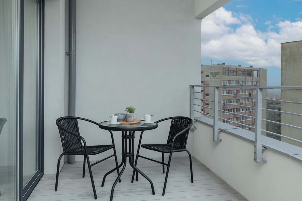 Another angle of the balcony with a table and chairs, emphasizing the outdoor living space and beautiful view.