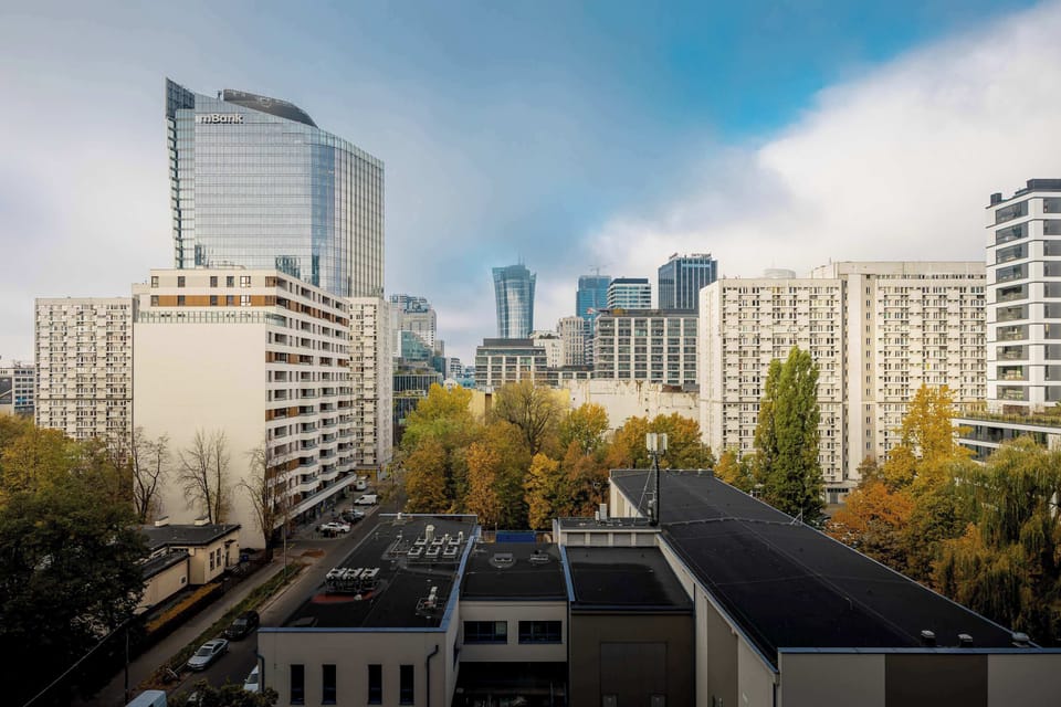 A cityscape view featuring tall buildings surrounded by trees, capturing the essence of urban living.