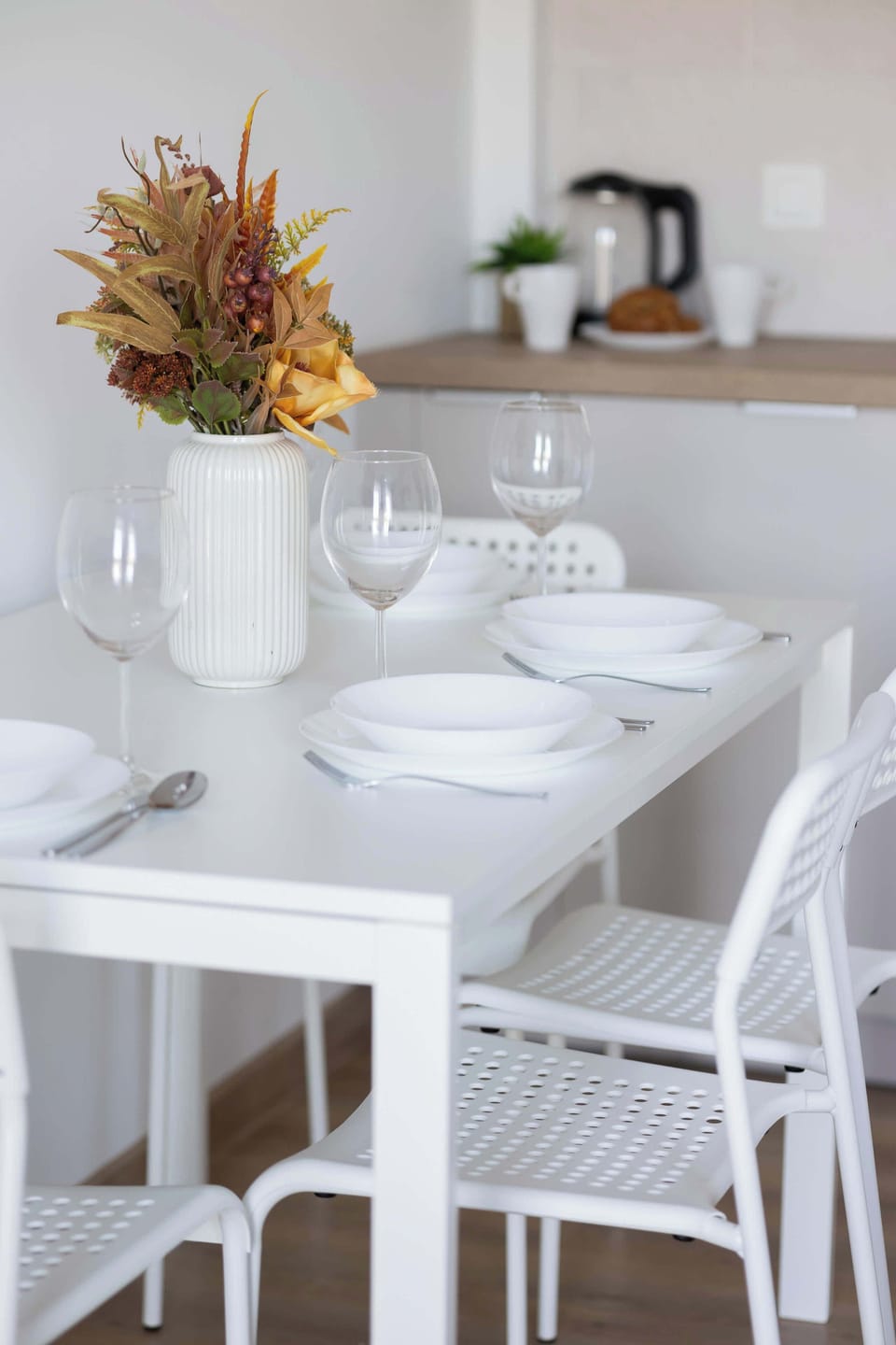 Functional dining area with table and chairs located next to the practically equipped kitchenette.