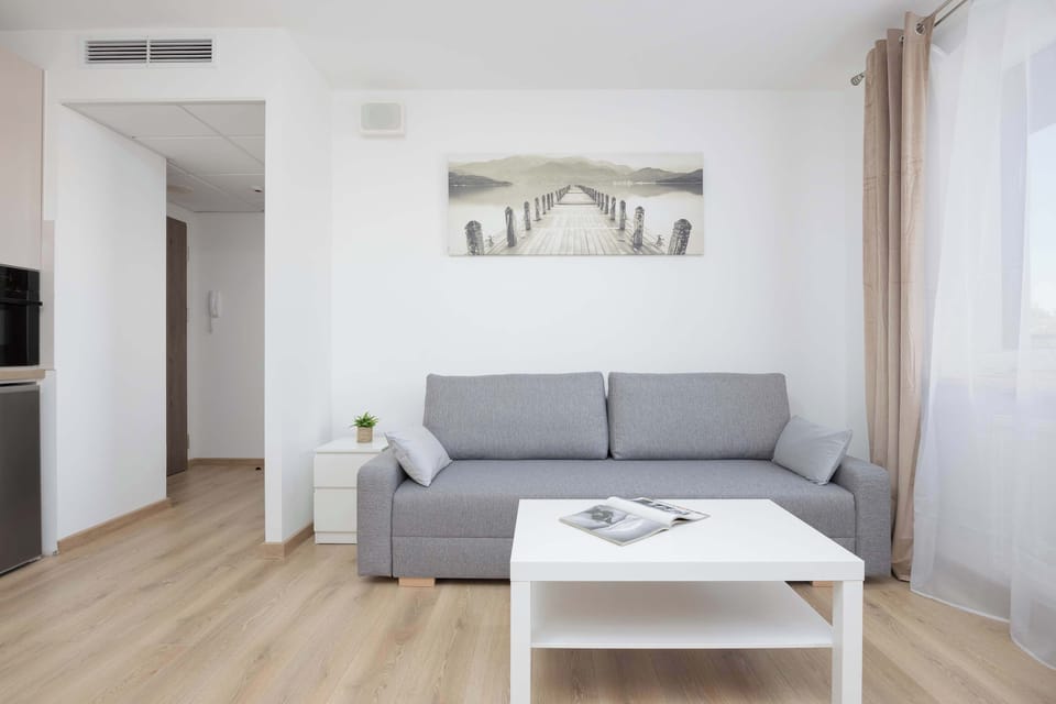 Living room with comfortable double sofa bed, dining area, and kitchenette.