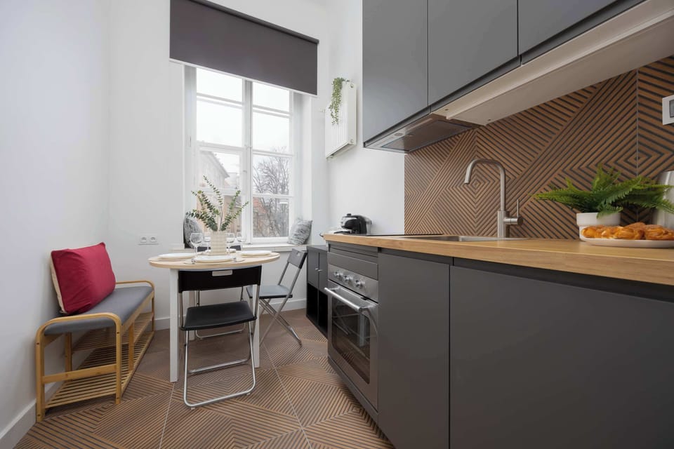Fully equipped kitchen with induction cooktop, oven, electric kettle, coffee maker, refrigerator with freezer, toaster, dishwasher and dining area.