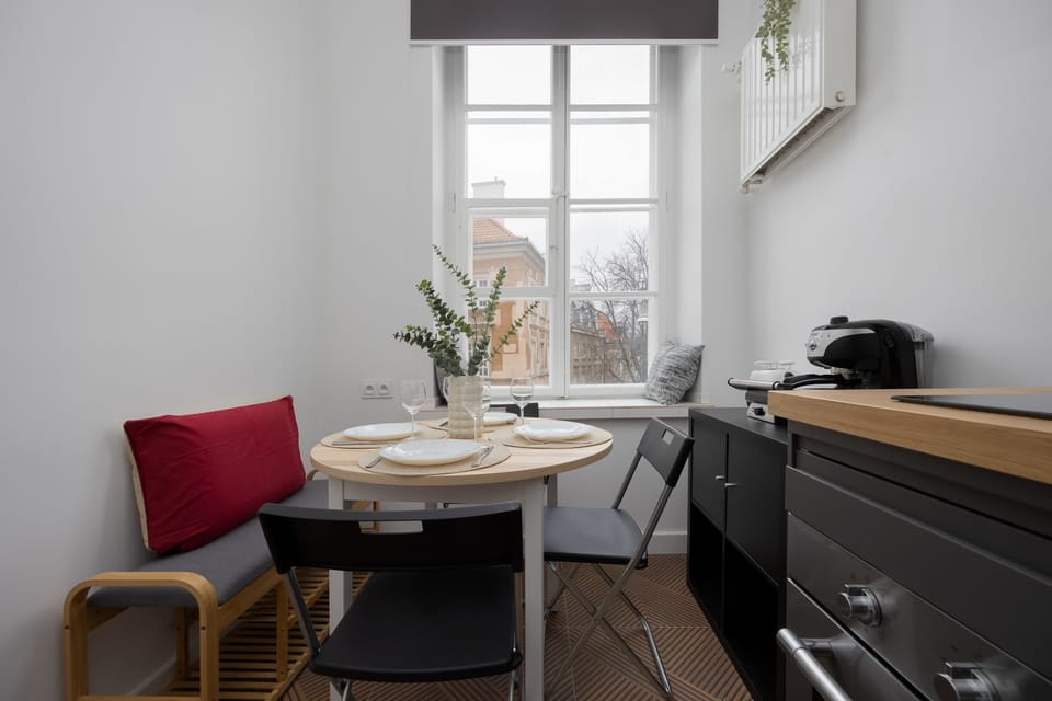 Fully equipped kitchen with induction cooktop, oven, electric kettle, coffee maker, refrigerator with freezer, toaster, dishwasher and dining area.