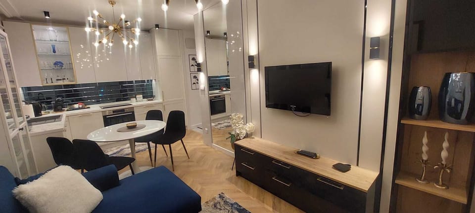 A spacious living room with a comfortable corner sofa and a large wall-mounted TV invites relaxation and evening entertainment.