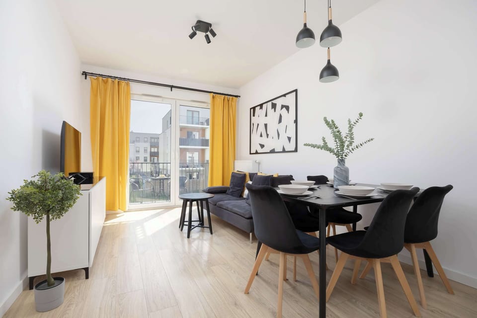 A view into the dining area with yellow curtains adding a cheerful touch, and the table set for meals.