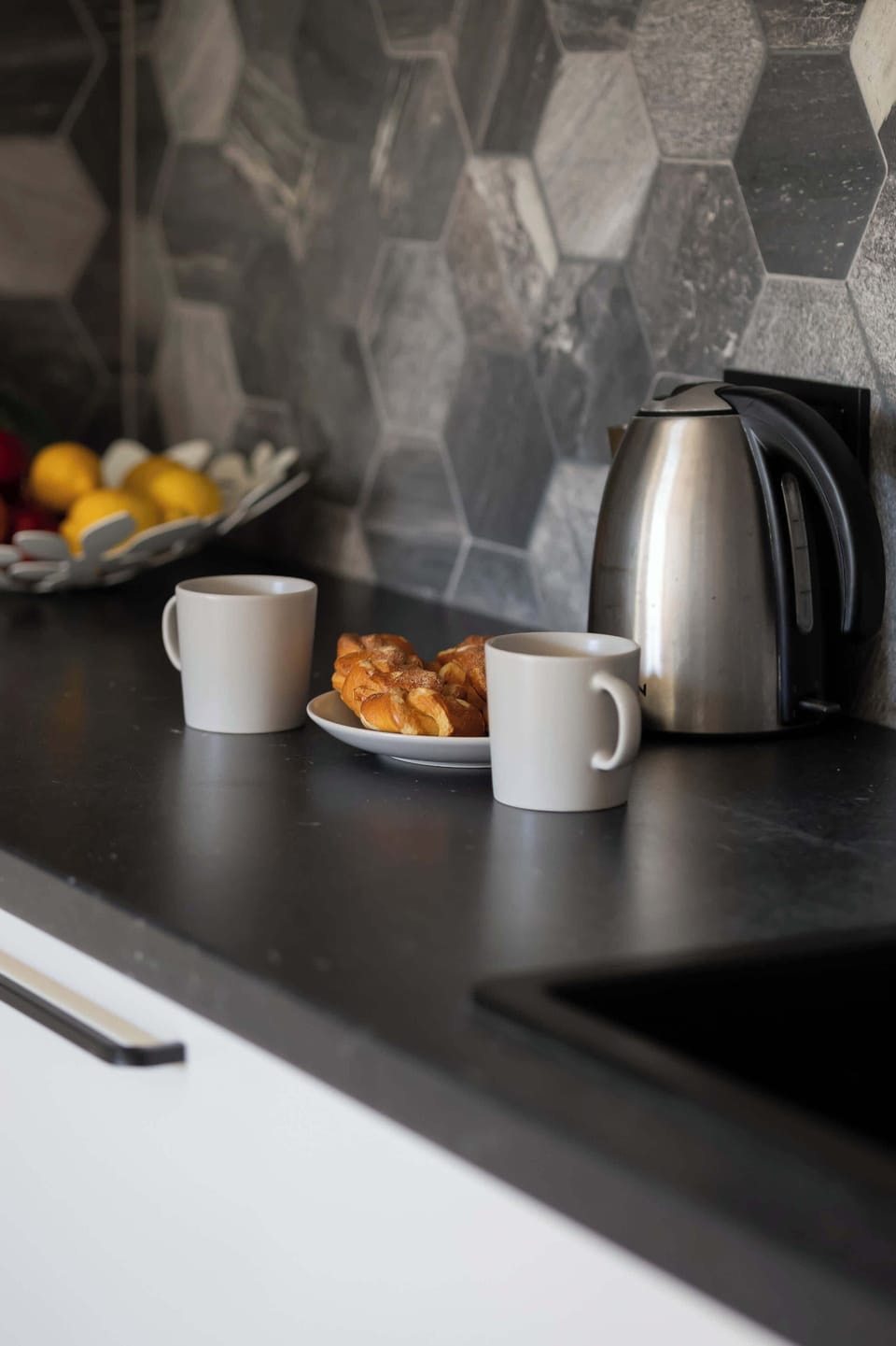 A close-up of the kitchen countertop with a kettle, mugs, and breakfast essentials, highlighting the cozy ambiance.