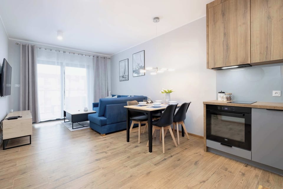 The living area features a sleek coffee table and a flat-screen television.