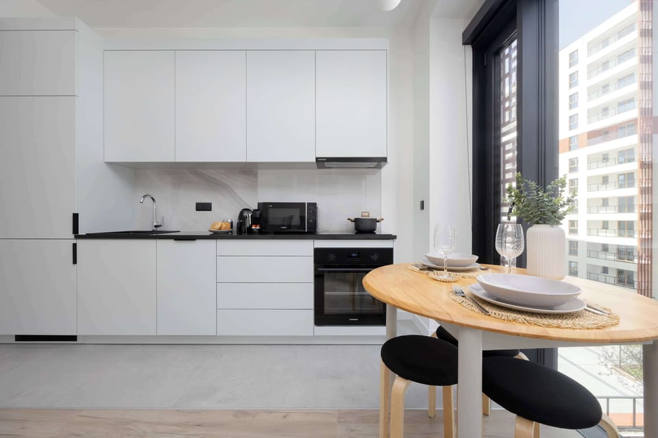The stylish kitchen with a round table and tall windows is perfect for intimate breakfasts.