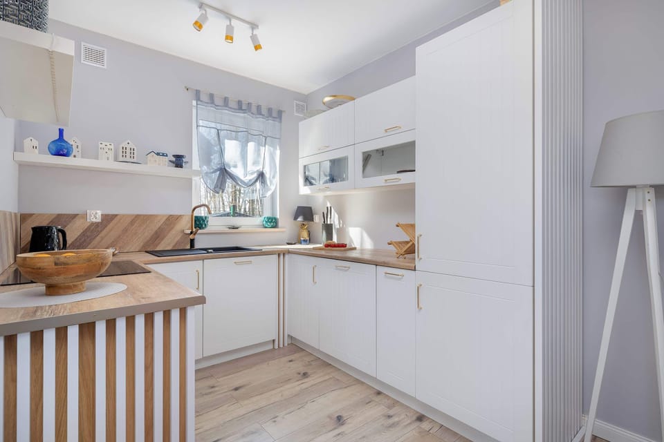 The kitchen in the cottage is a combination of white and wood, which creates an exceptionally warm and welcoming atmosphere. The bright interior encourages cooking together and spending time with the family.