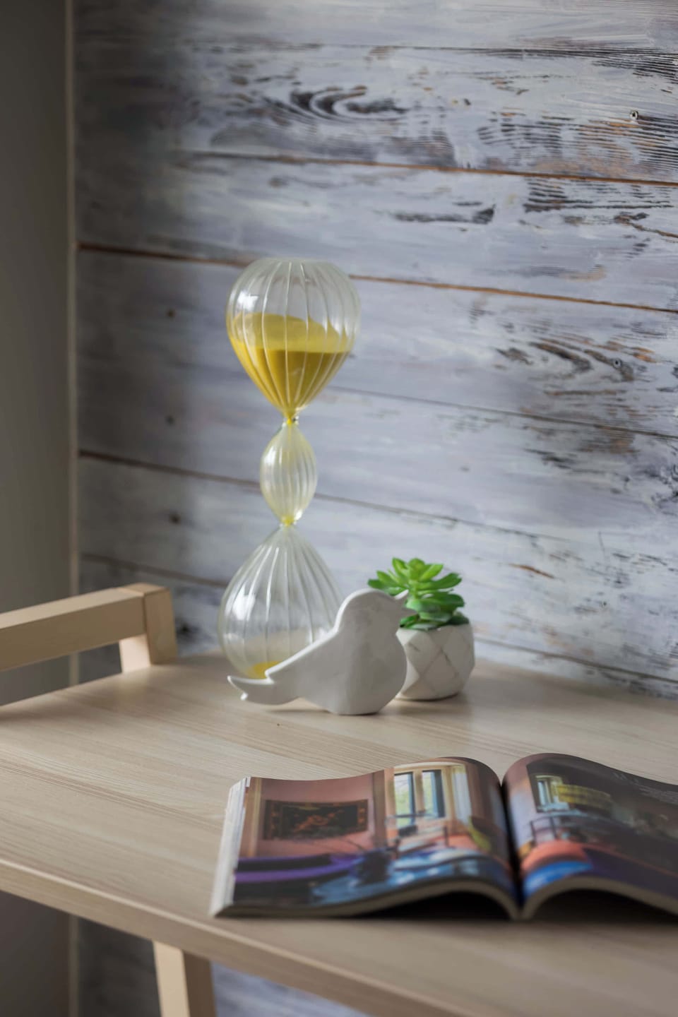 The detail with an hourglass and an open magazine adds an artistic, inspiring feel to the interior.