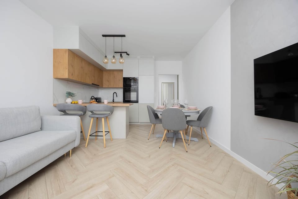 A large wall-mounted TV and bright interior set the scene for a calm evening unwind.

