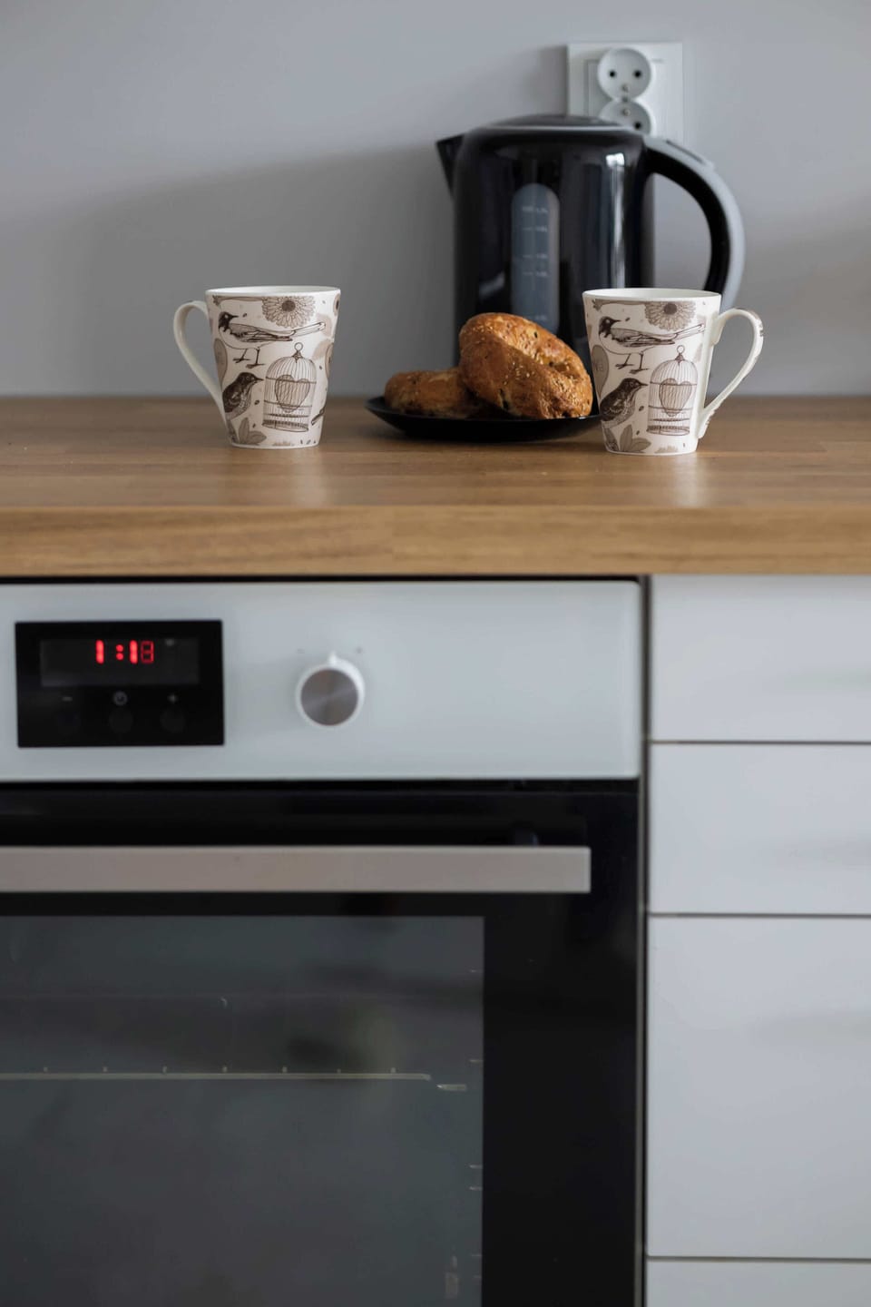 A stylish coffee setup with a kettle and cups sits on the counter, ready for guests to enjoy a fresh cup of coffee.