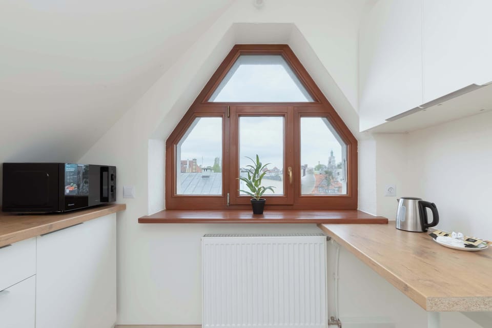 A large window lets natural light into the bright kitchen, making meal preparation more enjoyable. 