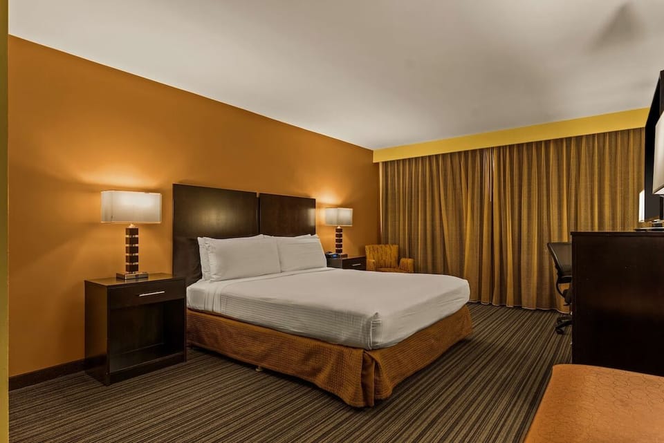 Unwind under warm lighting in a crisp, inviting king bed.